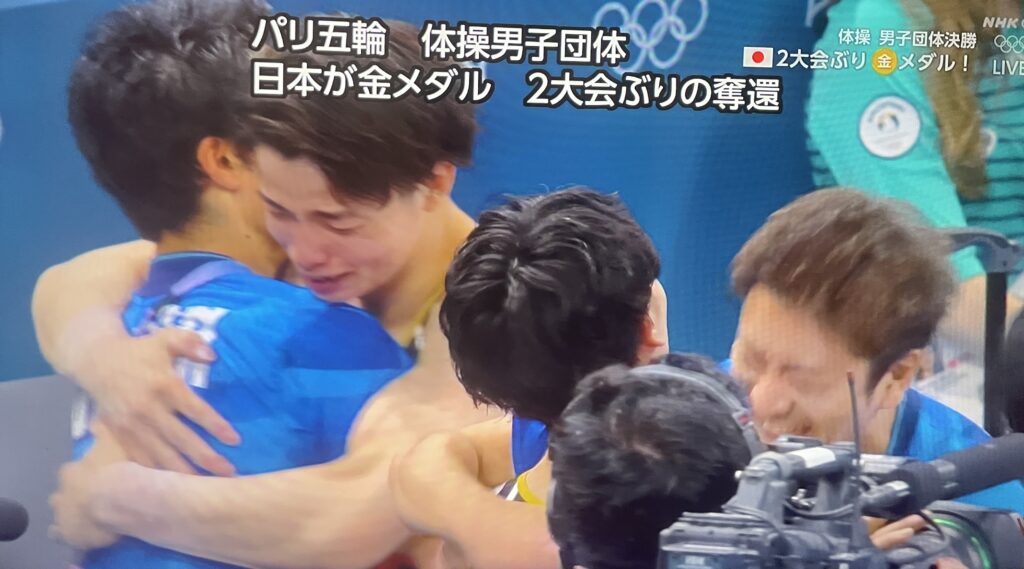 金メダルが確定し抱き合う選手たち